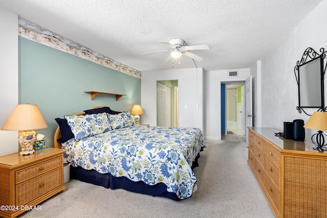 bedroom featuring ceiling fan, connected bathroom, and a textured ceiling