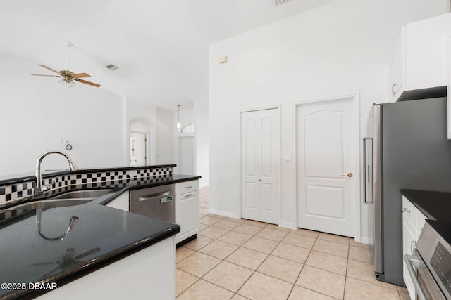 kitchen featuring a sink, dark countertops, white cabinetry, ceiling fan, and light tile patterned floors