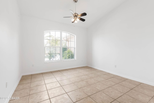 empty room with ceiling fan, light tile patterned floors, baseboards, and vaulted ceiling