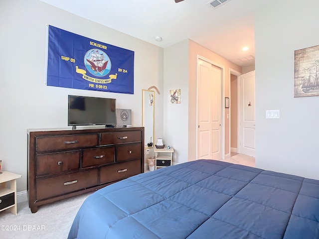 bedroom with light carpet and a closet