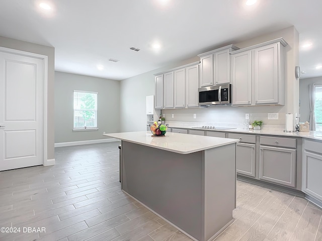 4155 Clifden Dr, Ormond Beach, FL 32174 - kitchen featuring electric stovetop, light wood-type flooring, a center island, and gray cabinetry