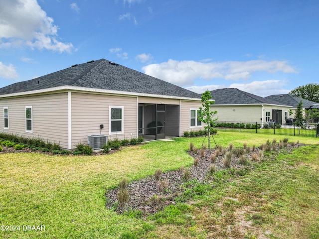 back of house with a lawn, central AC, and a sunroom