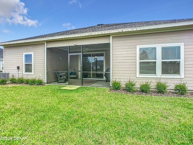 rear view of property featuring a sunroom, a yard, and a patio area