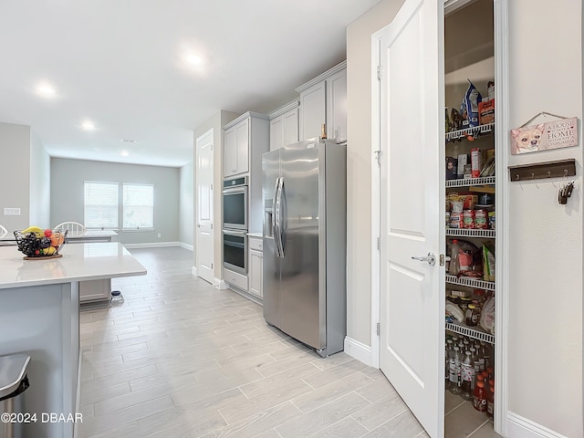 kitchen featuring gray cabinets, light wood-type flooring, and appliances with stainless steel finishes