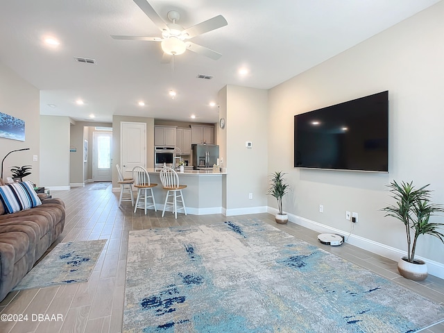 living room with hardwood / wood-style floors and ceiling fan