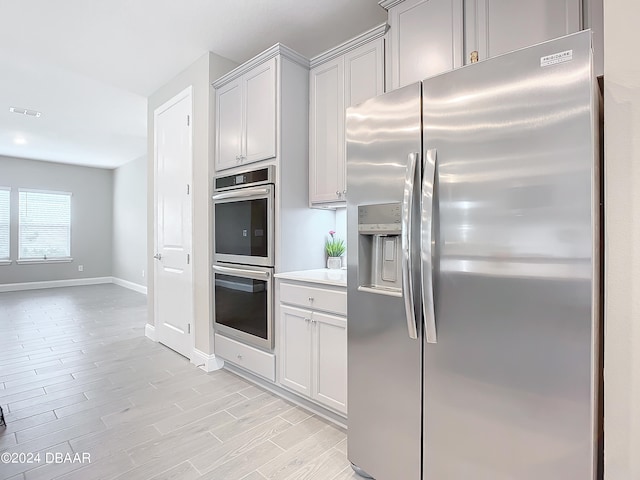 kitchen with appliances with stainless steel finishes and light hardwood / wood-style flooring