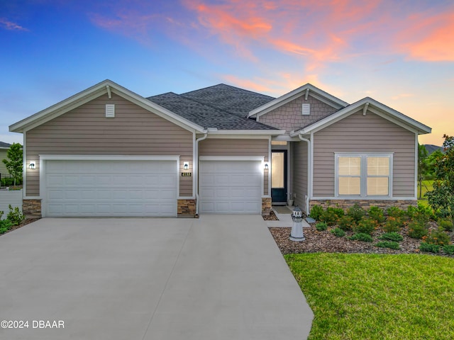 craftsman inspired home with a garage and a yard