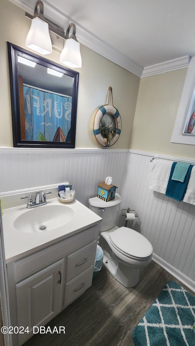 bathroom featuring toilet, vanity, hardwood / wood-style flooring, and crown molding