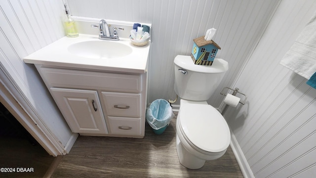 bathroom with toilet, vanity, and hardwood / wood-style floors