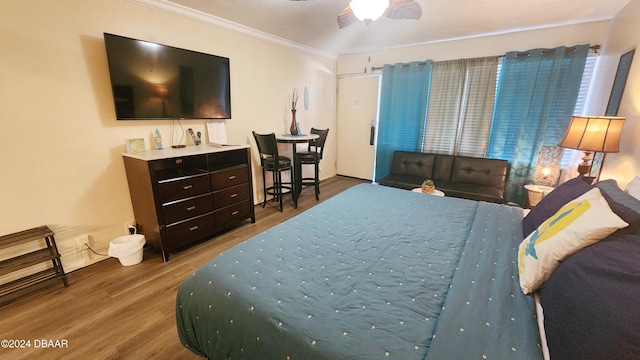 bedroom featuring ceiling fan, ornamental molding, and hardwood / wood-style flooring