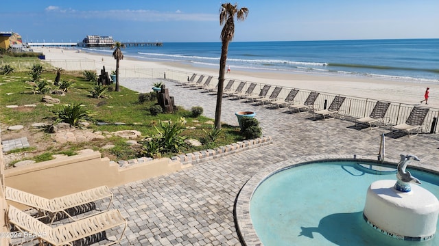 exterior space featuring a water view, a patio, and a view of the beach