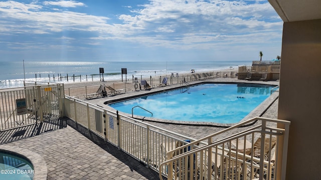 view of pool with a view of the beach and a water view