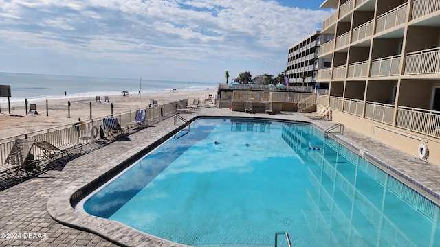 view of pool with a beach view and a water view