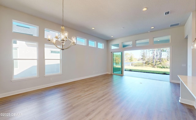 interior space with wood-type flooring and an inviting chandelier