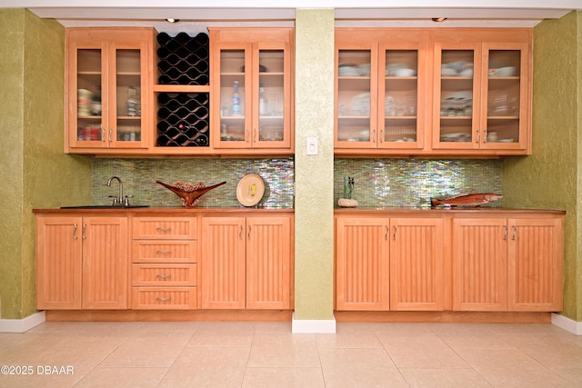 bar with light tile patterned flooring, backsplash, and sink