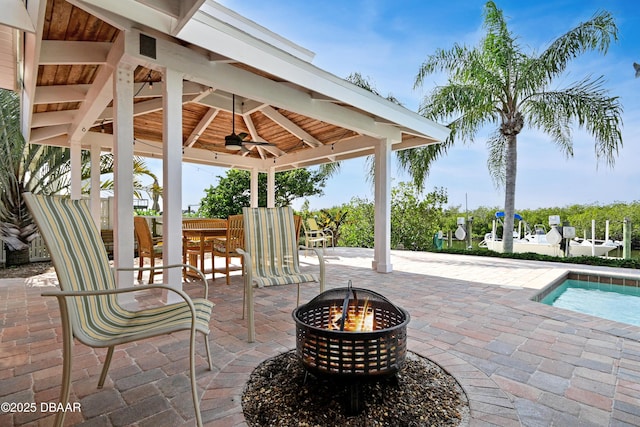 view of patio / terrace featuring a gazebo, a fire pit, and ceiling fan