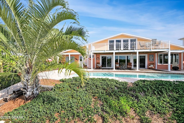 back of house featuring a balcony and a patio area