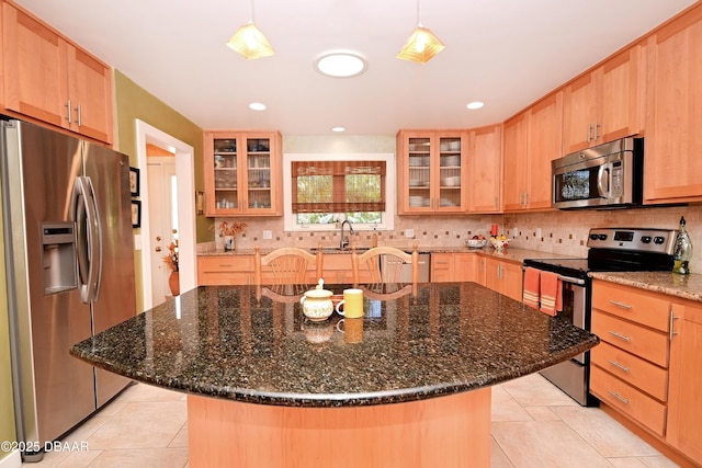 kitchen with sink, stainless steel appliances, a center island, and hanging light fixtures