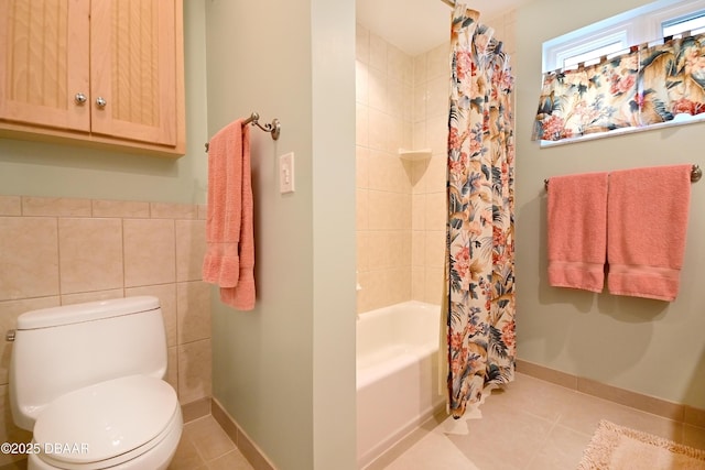 bathroom with tile walls, tile patterned flooring, shower / bath combo with shower curtain, and toilet