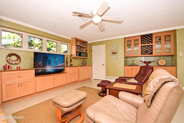 tiled living room featuring ceiling fan, crown molding, and sink