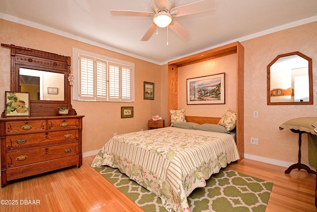 bedroom featuring ceiling fan, crown molding, and hardwood / wood-style flooring