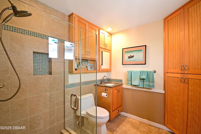 bathroom featuring toilet, tile patterned flooring, walk in shower, and vanity