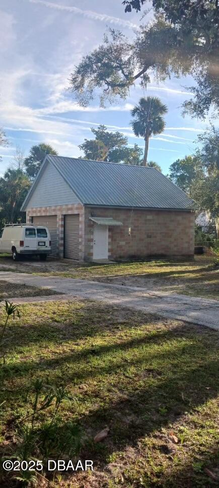 view of property exterior featuring a garage and a lawn