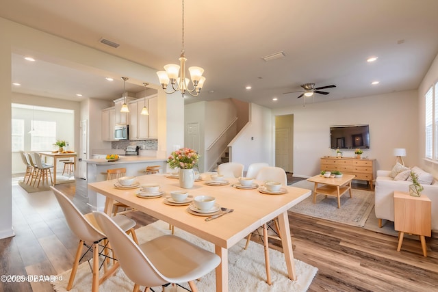 dining space with light wood-type flooring, stairway, visible vents, and recessed lighting