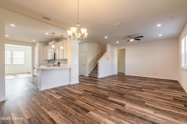 interior space featuring dark wood-style flooring, stainless steel appliances, visible vents, decorative backsplash, and open floor plan