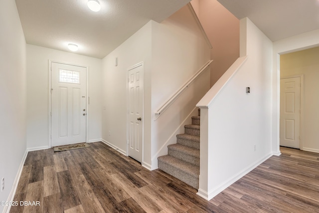 entrance foyer featuring stairway, baseboards, and wood finished floors