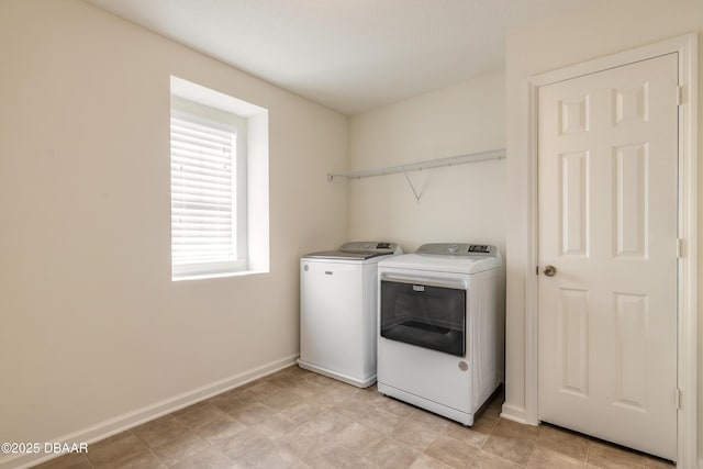 clothes washing area featuring laundry area, baseboards, and separate washer and dryer