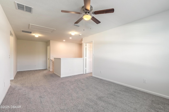 spare room with carpet flooring, visible vents, and baseboards