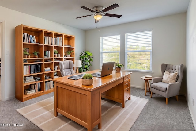 office space with light carpet, ceiling fan, and baseboards