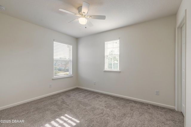 unfurnished room with carpet, plenty of natural light, baseboards, and ceiling fan