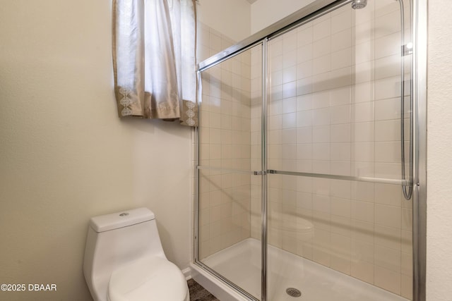 bathroom with a stall shower and toilet