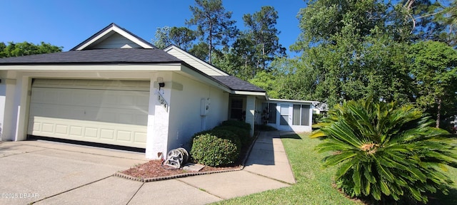 view of property exterior with a garage and a lawn