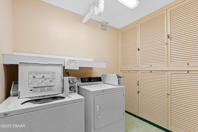 laundry room featuring independent washer and dryer and a textured ceiling