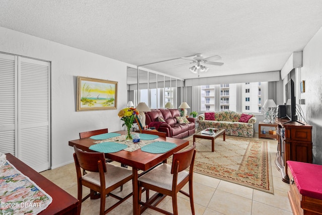 tiled dining area featuring a textured ceiling, plenty of natural light, and ceiling fan