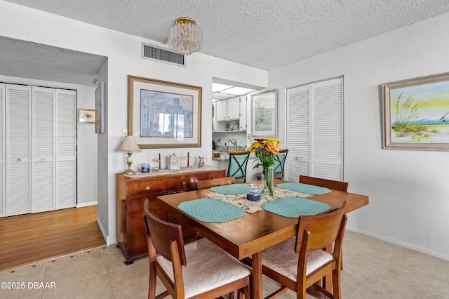 tiled dining space featuring a textured ceiling