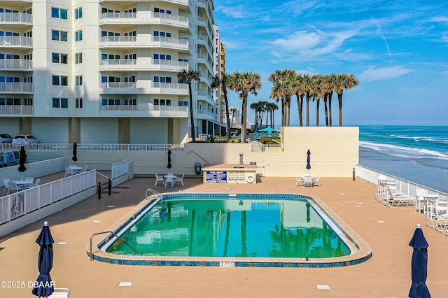 view of swimming pool featuring a patio and a water view