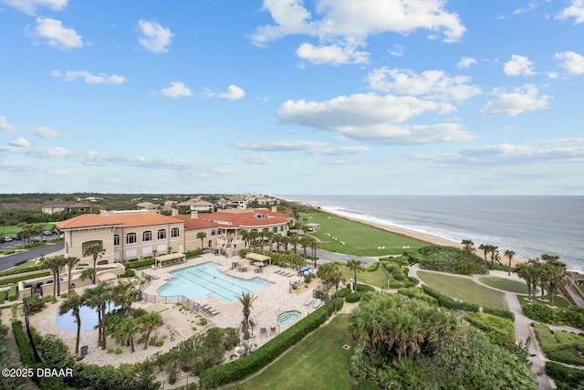 birds eye view of property with a water view and a beach view