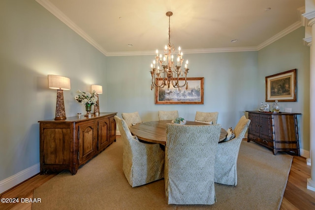 dining room featuring ornamental molding, light hardwood / wood-style floors, and a notable chandelier