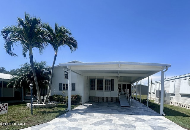 69 Turquoise Ave, Naples, FL 34114 - view of front of house with driveway, an attached carport, and a front lawn