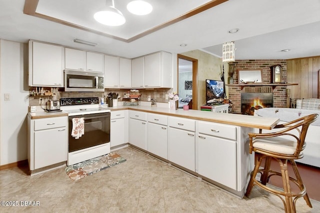 5967 Plantera Ct, Port Orange, FL 32127 - kitchen with stainless steel microwave, white range with electric stovetop, a peninsula, and light countertops