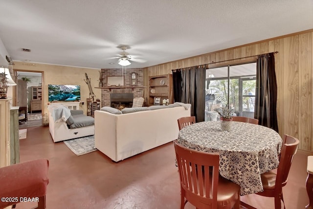 5967 Plantera Ct, Port Orange, FL 32127 - living area featuring a brick fireplace, ceiling fan, wooden walls, a textured ceiling, and concrete floors