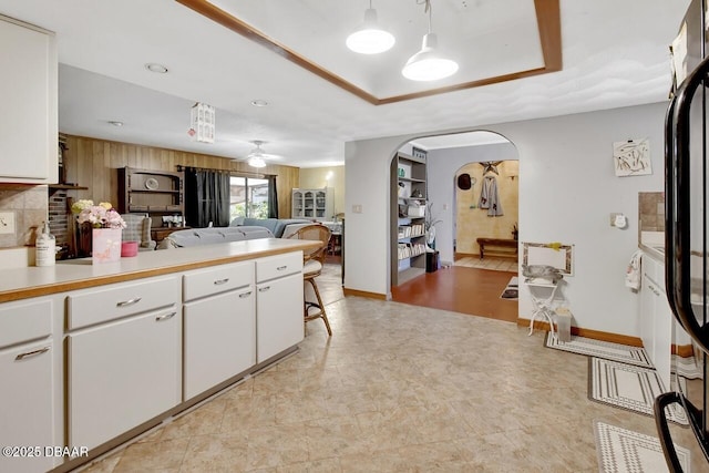5967 Plantera Ct, Port Orange, FL 32127 - kitchen featuring arched walkways, ceiling fan, white cabinetry, light countertops, and baseboards