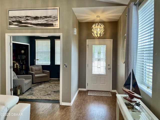 entrance foyer with an inviting chandelier and dark hardwood / wood-style floors