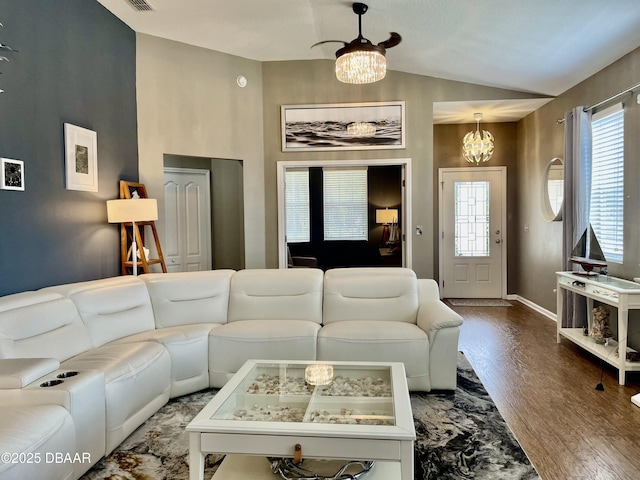 living room featuring lofted ceiling, hardwood / wood-style floors, and a notable chandelier