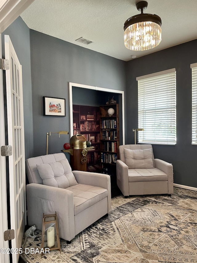 living room with a textured ceiling and a chandelier