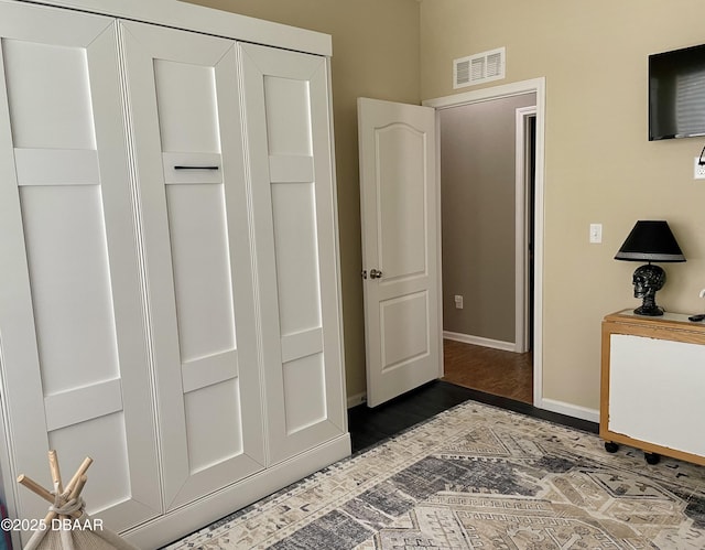 bedroom featuring dark wood-type flooring and a closet